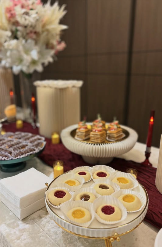 Dessert table with lemon and raspberry tartlets on a burgundy runner