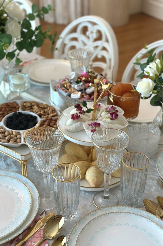 Table detail with gold-rimmed glasses, nuts and sweets